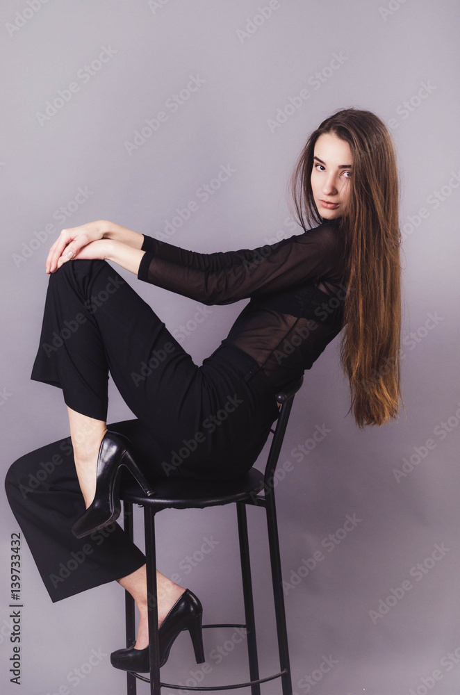 Beautiful woman in black clothes posing for the camera portrait young studio on gray. Beautiful woman in black clothes posing for the camera portrait young studio on gray.