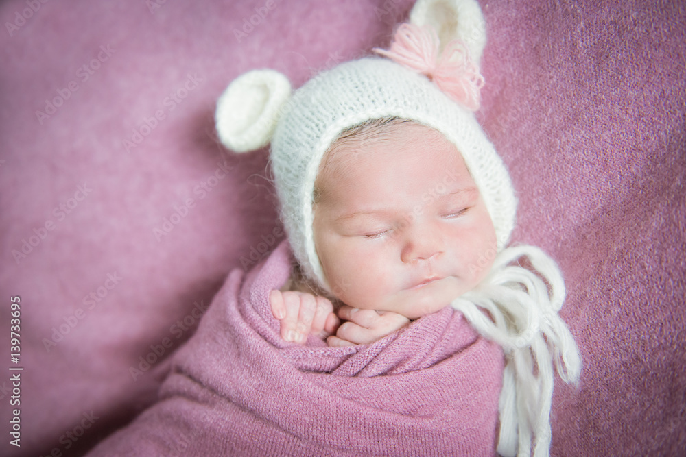 Newborn baby sleeps in a hat with ears on a pink blanket StockFoto