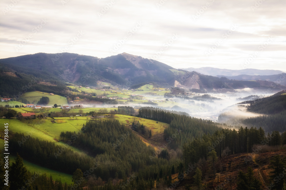 foggy morning at basque country valley, Spain