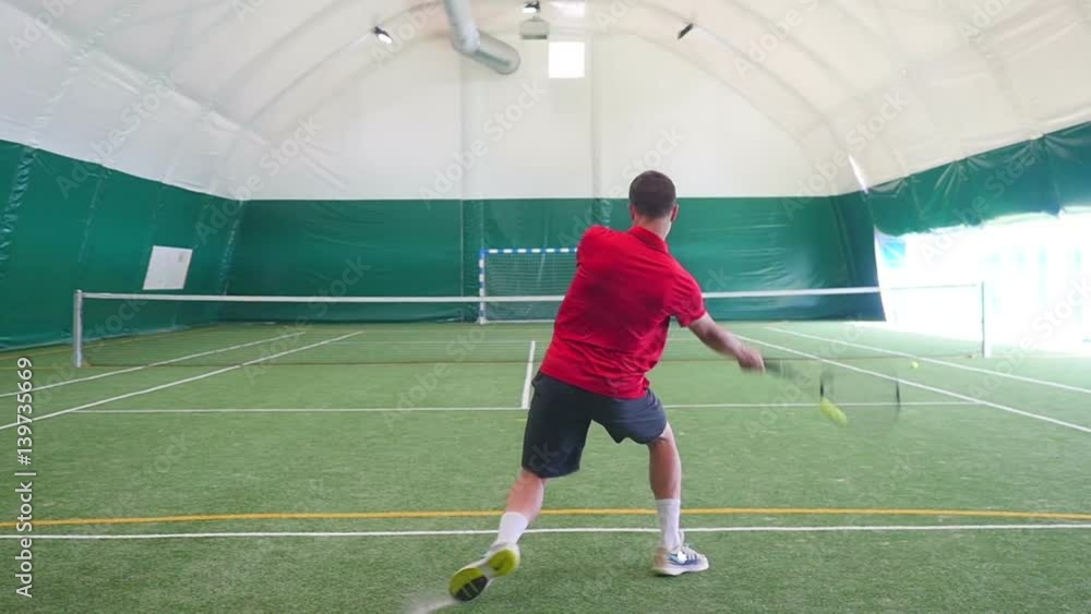 Man swings a racket and steps aside during playing tennis Man swings a racket and steps aside during playing tennis
