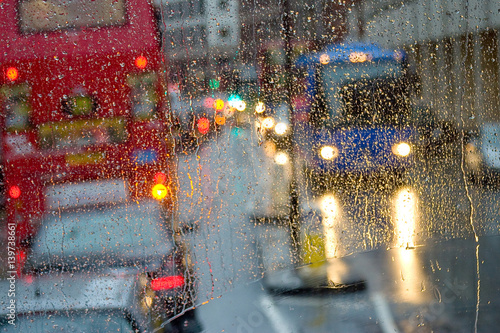 Rain in London view to red bus through rain-specked window