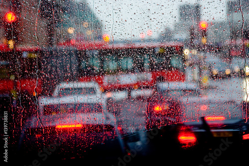 Rain in London view to red bus through rain-specked window