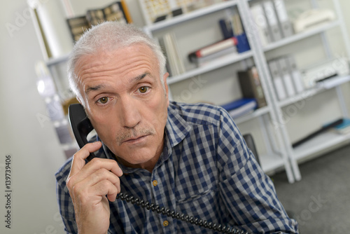 man on telephone, looking shocked