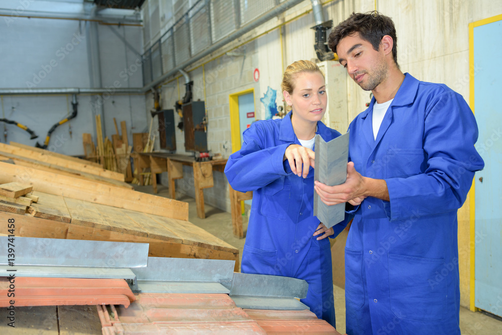© auremar - Workers looking at right angled metal