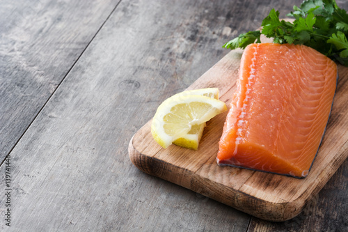 Raw salmon fillet on wooden background 