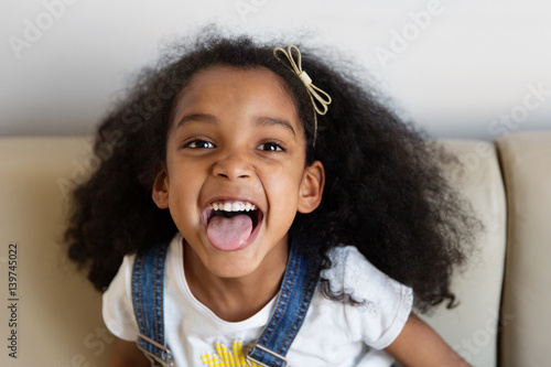 Portrait d'une petite fille qui tire la langue en riant photo