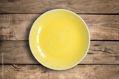 Top view of blank dish on a wood background.