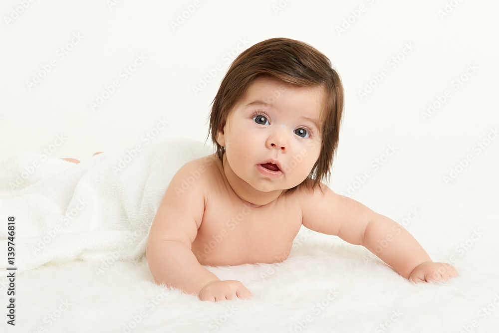 Adorably baby lie on white towel in bed. Happy childhood and healthcare concept. Yellow toned Adorably baby lie on white towel in bed. Happy childhood and healthcare concept. Yellow toned
