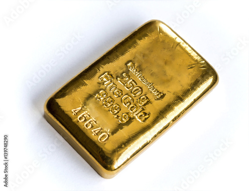 A cast gold bar weighing 250 grams is isolated on a white background. Selective focus.