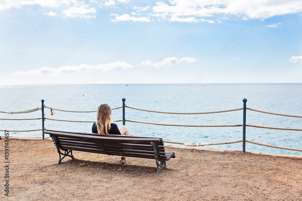 Alone young woman sitting on the bench