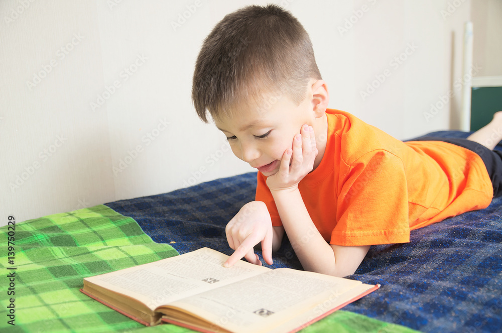 children education, boy reading book lying on bed, child portrait smiling with book, education concept, interesting storybook children education, boy reading book lying on bed, child portrait smiling with book, education concept, interesting storybook