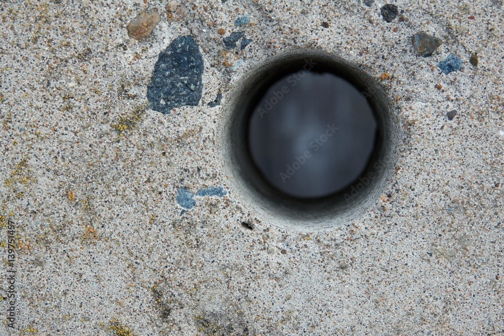 Hole in a concrete fence.