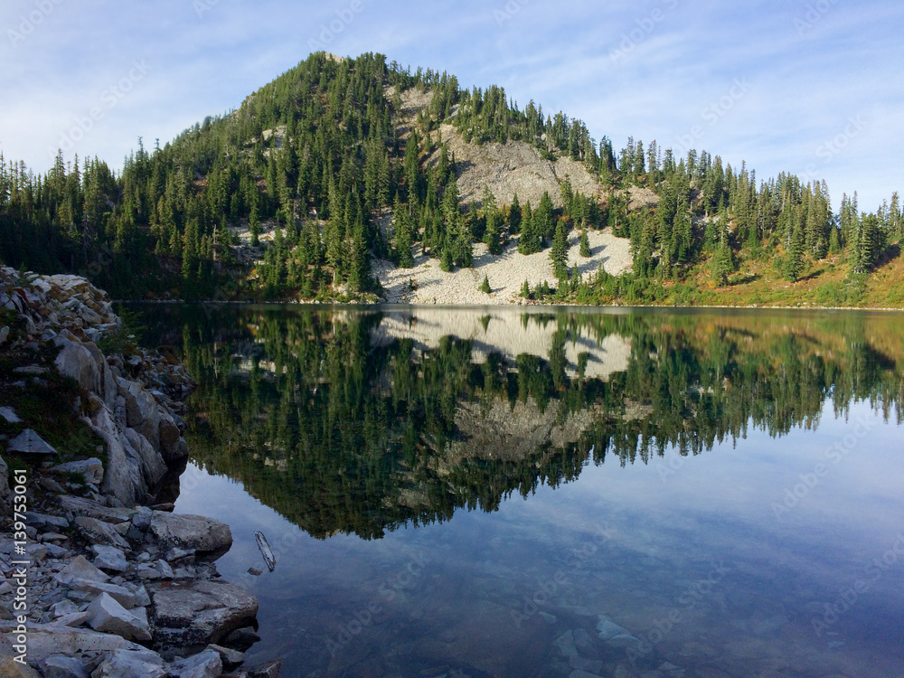 Mountain reflecting in lake in evergreen forest Mountain reflecting in lake in evergreen forest