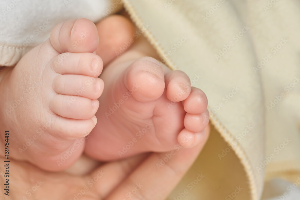 Parent holding in the hand feet of newborn baby