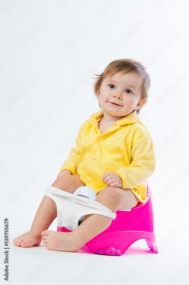 Little smiling girl sitting on a pot. Isolated on white background. Little smiling girl sitting on a pot. Isolated on white background.