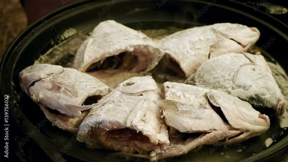 Cooking on the open fire. Pieces of freshwater fish fried in a cast-iron skillet. HD Cooking on the open fire. Pieces of freshwater fish fried in a cast-iron skillet. HD