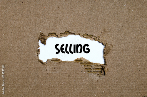 The word selling appearing behind torn paper photo