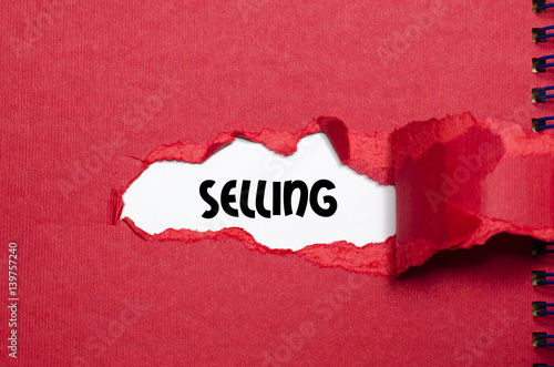 The word selling appearing behind torn paper