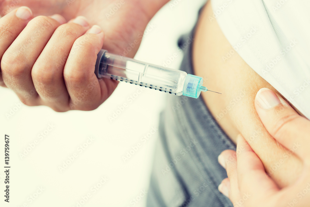 close up of hands making injection by insulin pen close up of hands making injection by insulin pen