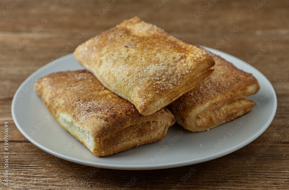 Delicious puff pastry with apples on a wooden background