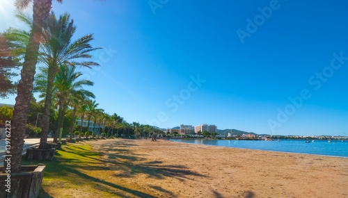 Ibiza sun shines of the beach in Sant Antoni de Portmany, Take a walk along main boardwalk or in the sand. November beach in warm morning sunshine. 