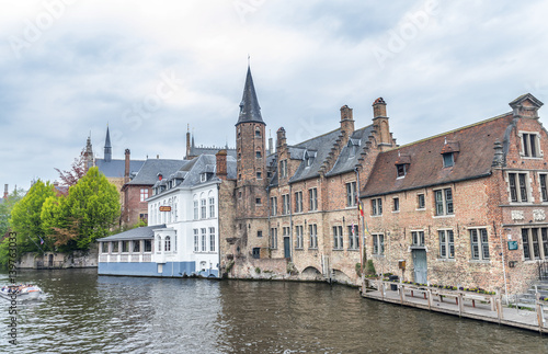 BRUGES, BELGIUM - MARCH 2015: Tourists visit ancient medieval city on a cloudy day. Brugge attracts more than 2 million people annually