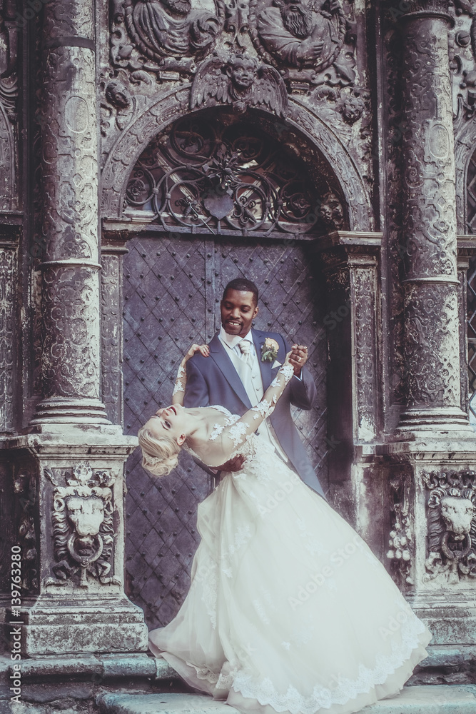 Happy handsome african groom and cute bride smiling Happy handsome african groom and cute bride smiling