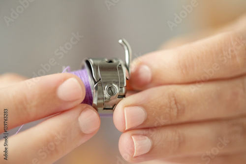 tailor hands with spool of sewing machine