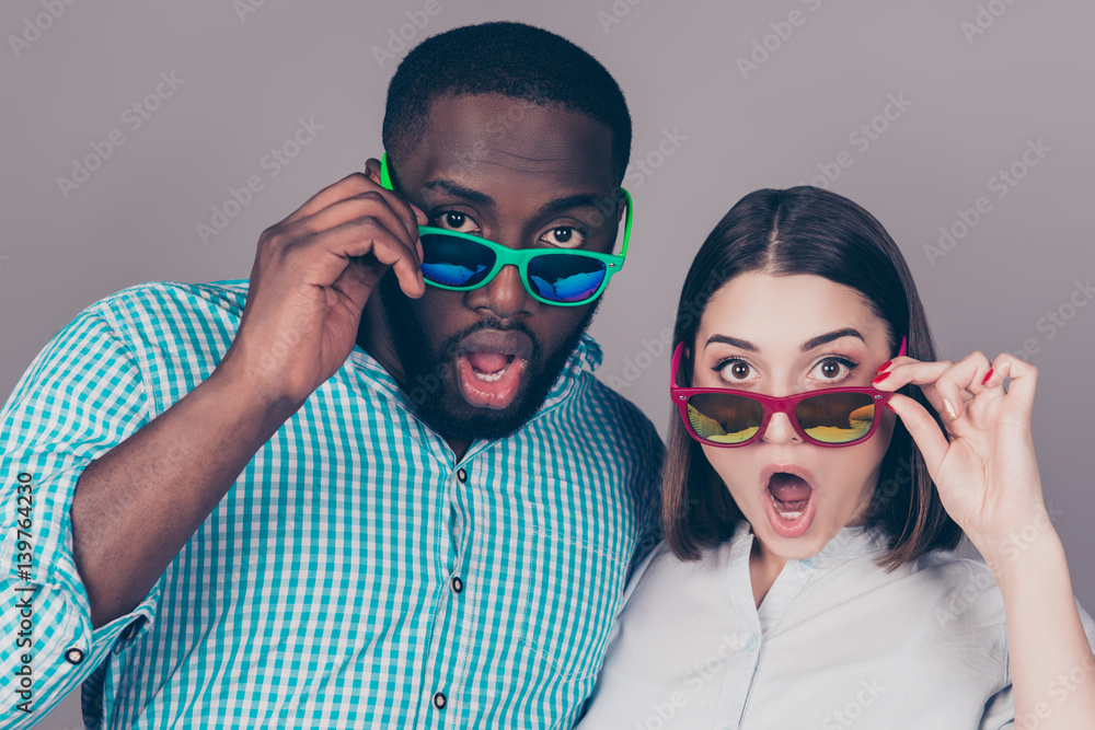 Portrait of shocked young multinational couple in love in glasses Portrait of shocked young multinational couple in love in glasses