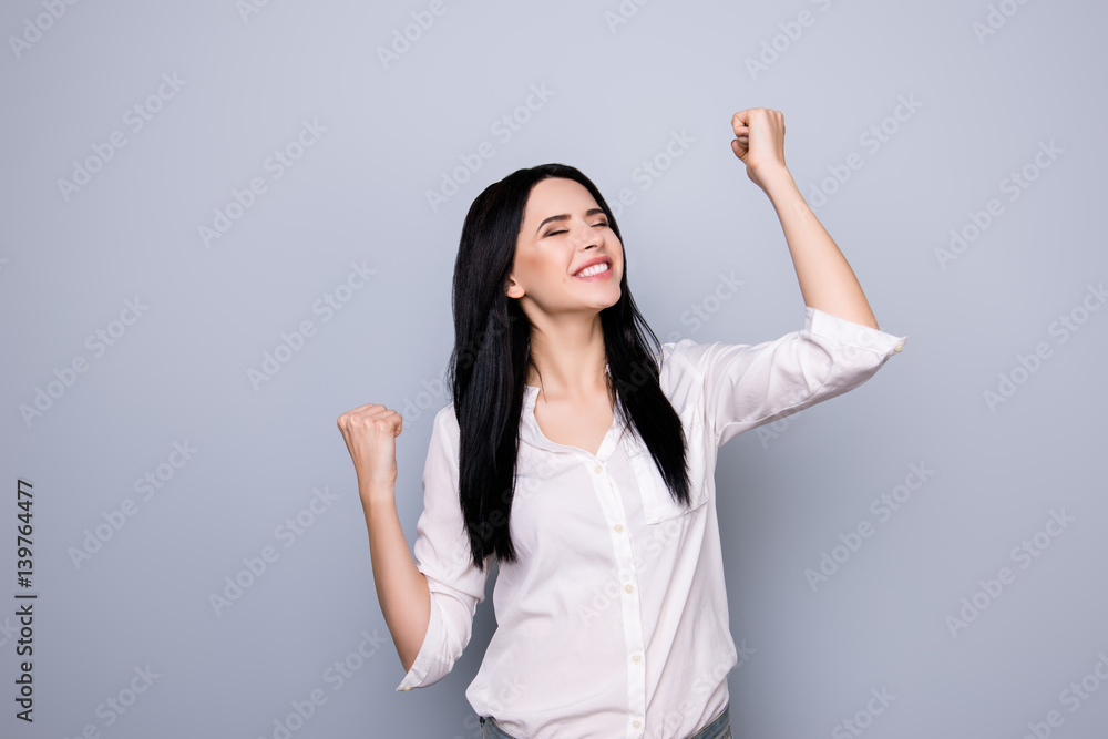 Portrait of happy cute young woman with toothy smile raised hands and celebrate achievement goal Portrait of happy cute young woman with toothy smile raised hands and celebrate achievement goal
