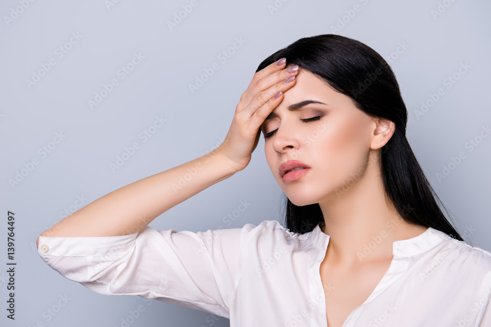 Exhausted overworked beautiful young woman in formalwear with black hair touching head, she suffering from strong headache Exhausted overworked beautiful young woman in formalwear with black hair touching head, she suffering from strong headache