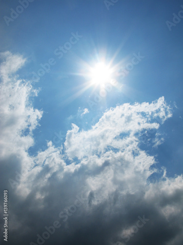 Fantastic sun and white clouds on the blue sky photo