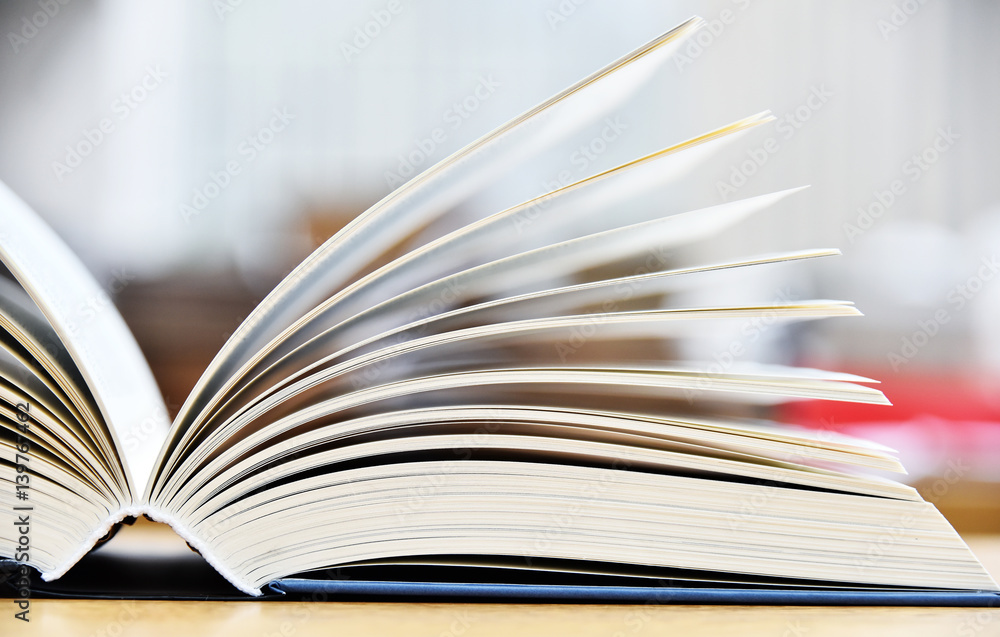 Fototapeta premium Hardcover book lying on the table in a library