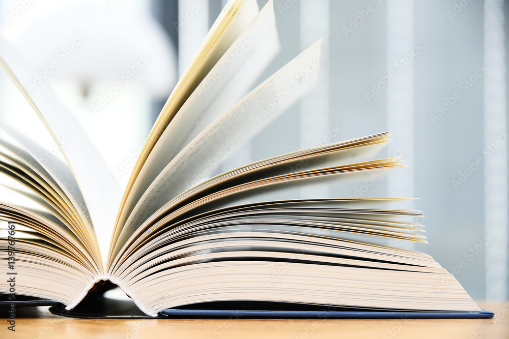 Fototapeta premium Hardcover book lying on the table in the library