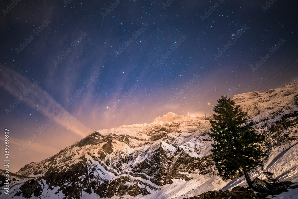 view up to a massive mountain in a clear winter night with shiny stars