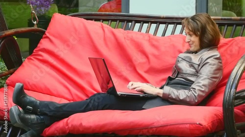 Young business woman with laptop on the swing bed photo