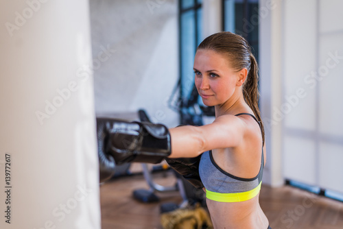 Attractive Female Punching A Bag With Boxing Gloves On © romankosolapov