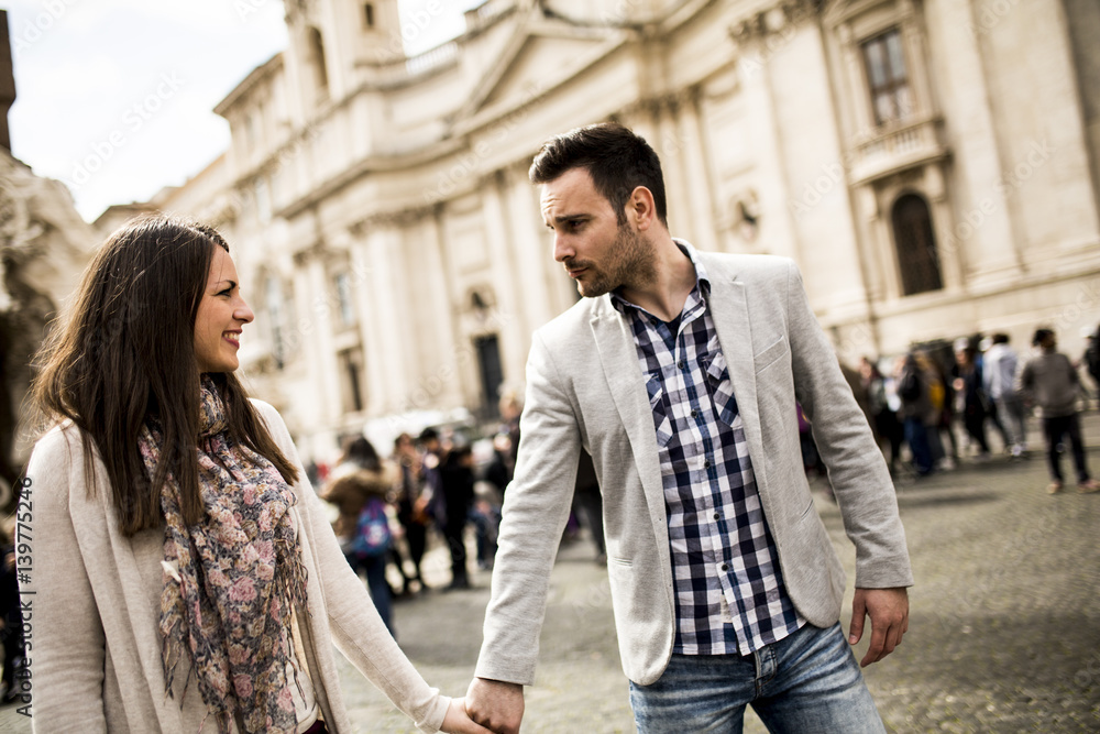 Casual young couple holding hands walking in Rome, Italy, Europe Casual young couple holding hands walking in Rome, Italy, Europe