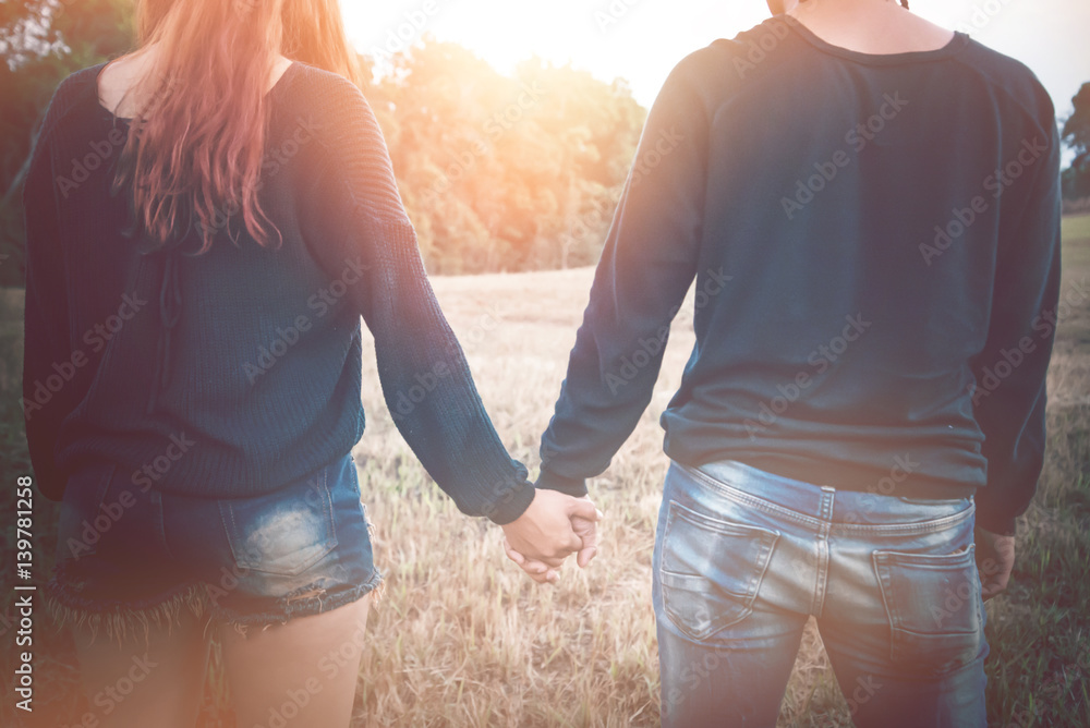 Lovers walk hand in hand on romantic evening sun, romantic atmosphere. Lovers walk hand in hand on romantic evening sun, romantic atmosphere.