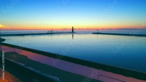 Wallpaper Mural Twilight flight over cold harbor with stunning fiery horizon, lighthouse.
 Torontodigital.ca