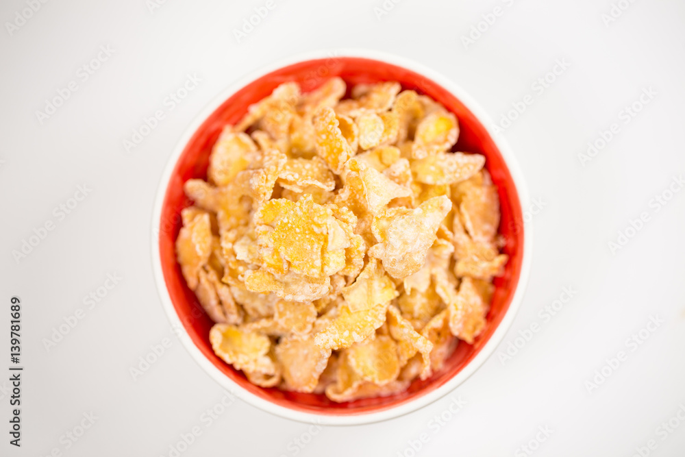 bowl of sugar-coated corn flakes isolated on white. bowl of sugar-coated corn flakes isolated on white.