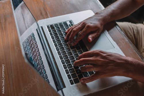 Close up, hands are typing on a keyboard of laptop - macbook