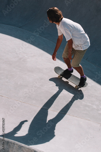 Skater rides in a concrete ground in a pool, during daylight, Indonesia, Bali