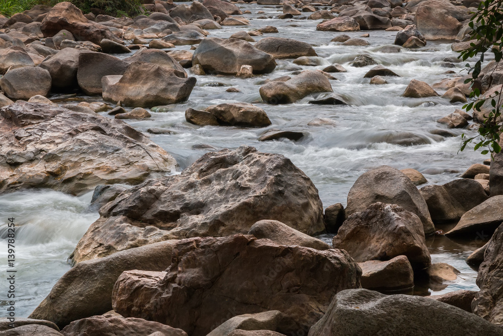 Beautiful River water flowing through stones and rocks at dawn