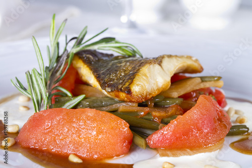 Pike perch fillet baked with arrows of garlic and blanched tomatoes