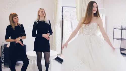 Young woman chooses a wedding dress in bridal shop