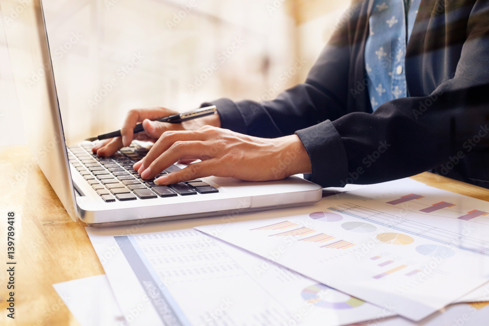 Businesswoman working and analyzing investment charts on desk in office. Businesswoman working and analyzing investment charts on desk in office.