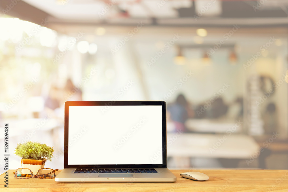 Mock up Blank screen of Laptop on wood table in Co-working or cafe. Mock up Blank screen of Laptop on wood table in Co-working or cafe.