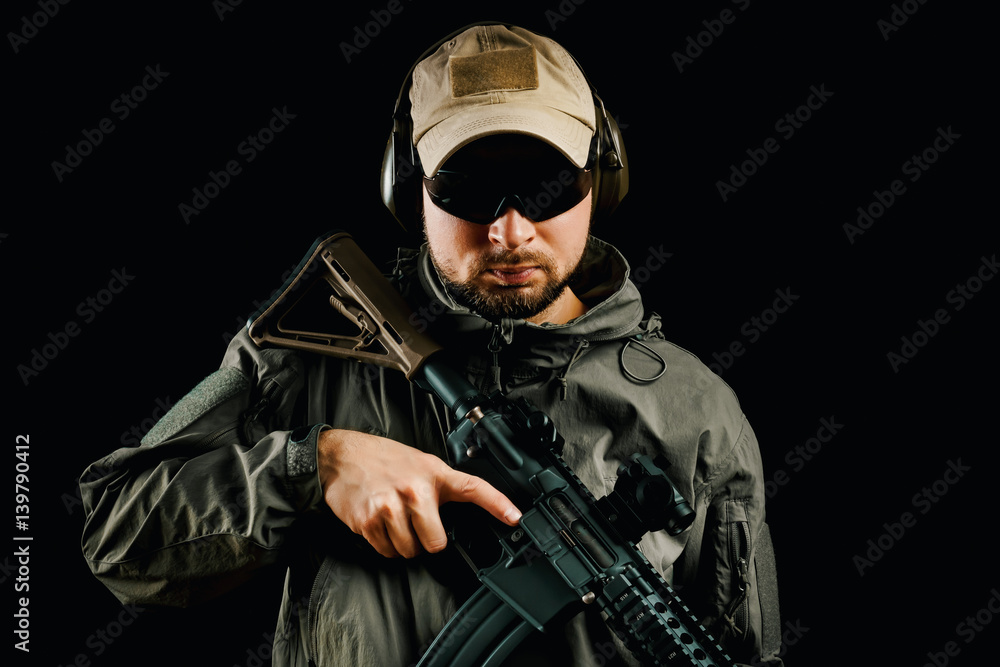 man in cap and jacket keeps assault rifle man in cap and jacket keeps assault rifle