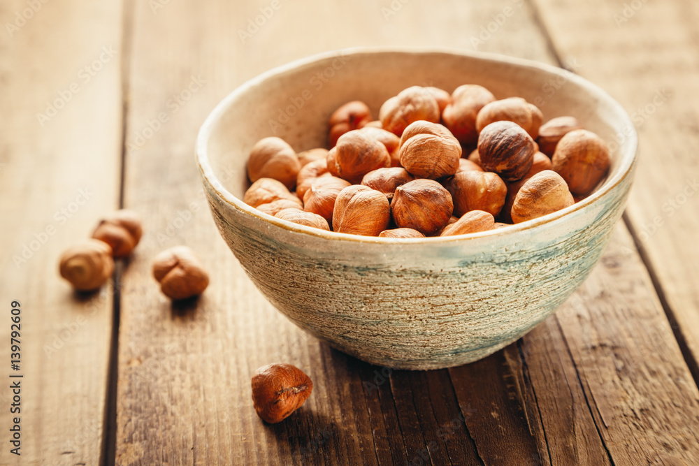 hazelnuts iHazelnuts in a bowl on a old rustic table. Shallow DOFn a bowl hazelnuts iHazelnuts in a bowl on a old rustic table. Shallow DOFn a bowl